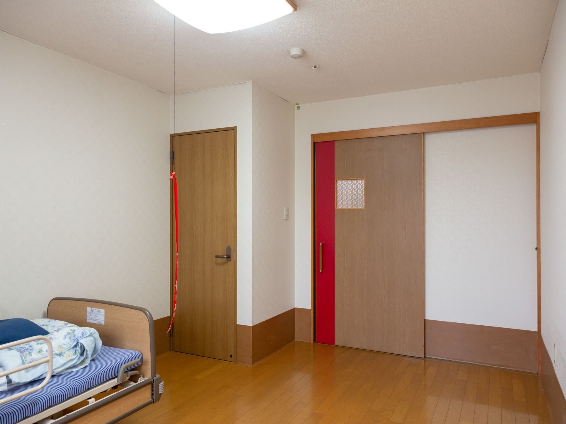 大きなスライド式ドアが設置されたフローリングタイプの居室