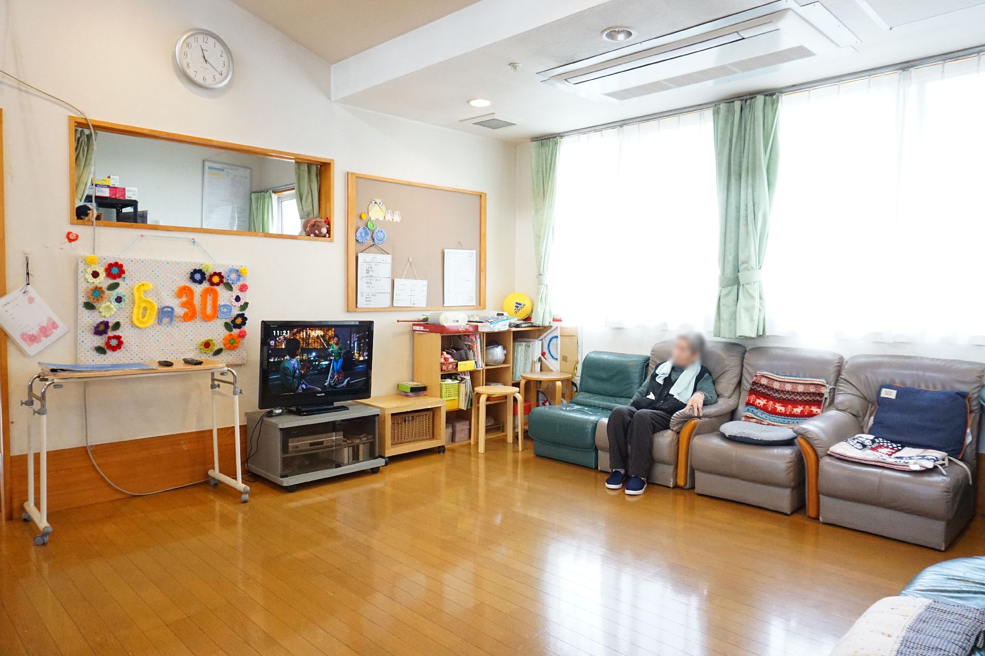 窓から陽光がたっぷりと入り、ソファーが多数設置されているリビング