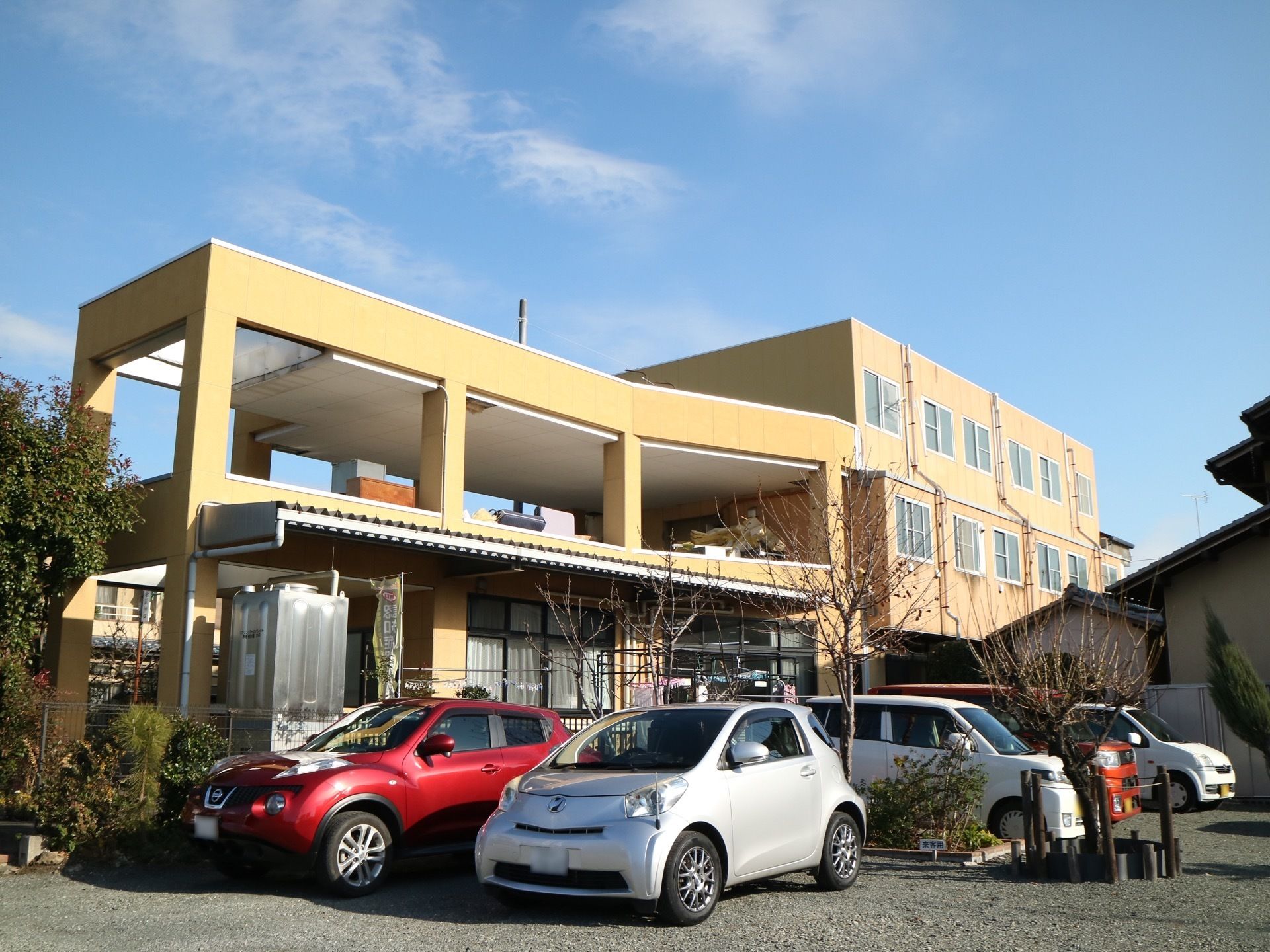 建物の裏手には砂利敷きの駐車場がある。駐車場に面して食堂があり、その上は屋根付きの広いテラスになっている。