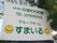 国道に向かって大きな看板が立っている。緑色の文字で上側に運営会社名、下側に施設名が記されている。施設名の両側にはロゴが描かれている。