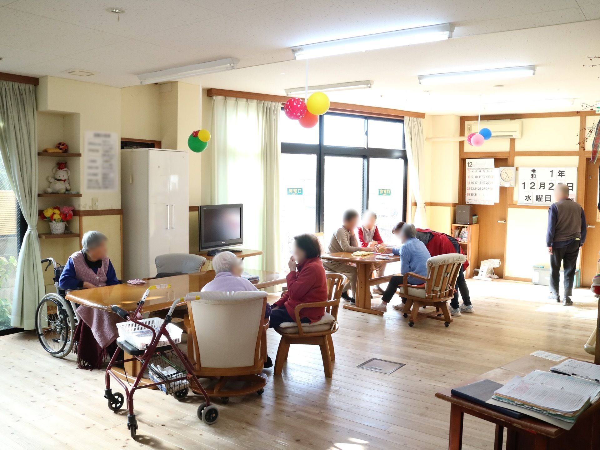 広い掃き出し窓を持つ部屋で、外の景色がよく見える。外光が差し込み大変明るい。部屋の中央壁際にテレビが設置されている。