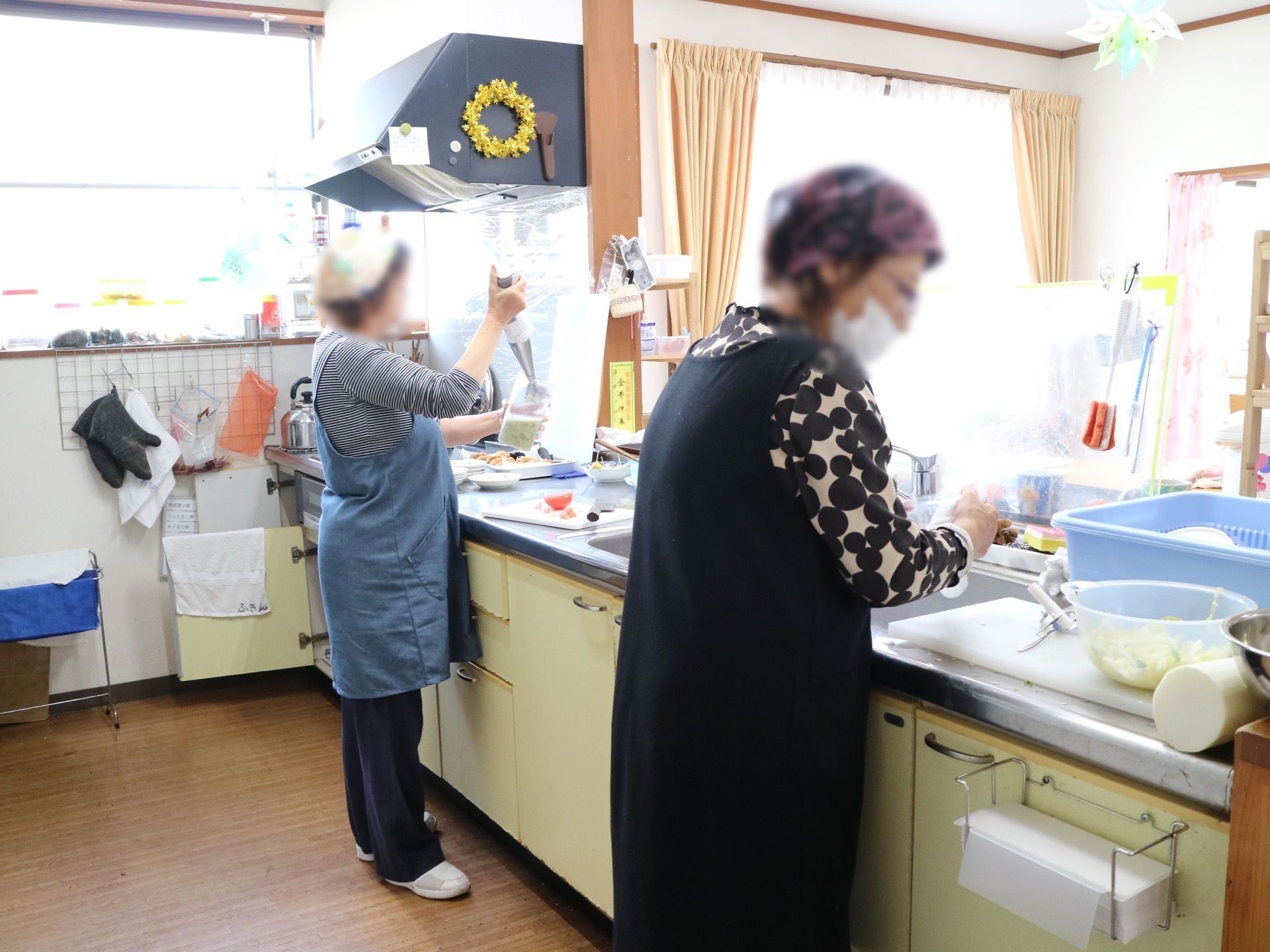 キッチンで調理をしているエプロンを付けた女性スタッフ
