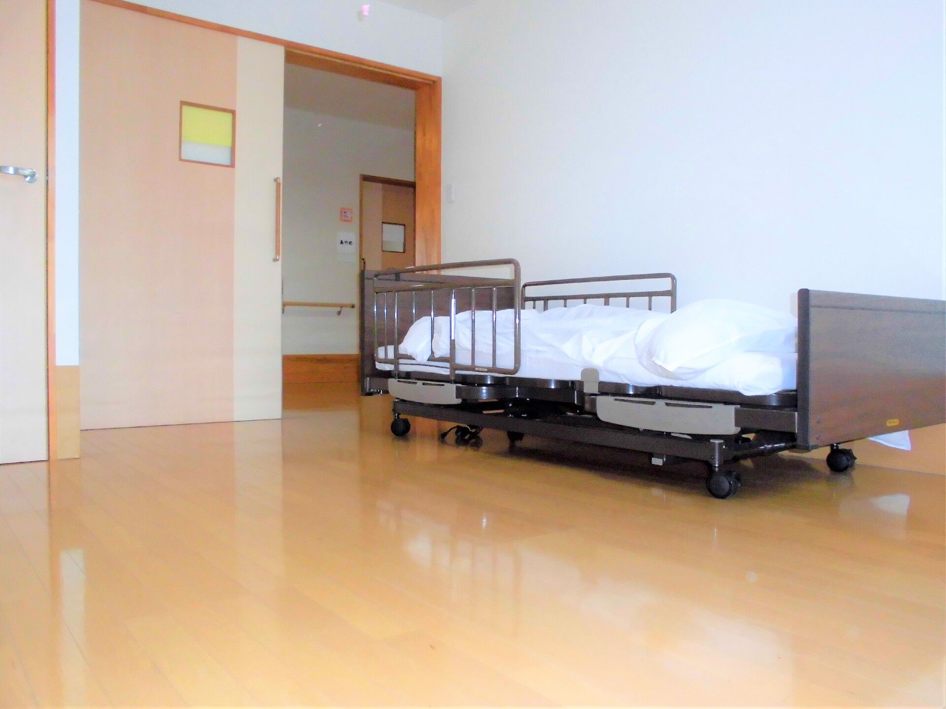 認知症の入居者に寄り添ったケアを実践するスタッフ。一緒にリビングの掃除をしている様子。