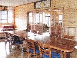床、家具、壁が木製のリビング。奥の窓から明るい光が差しこんでいる