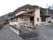 自然に囲まれたホーム。平屋建ての建物はベージュ系を基調としていて駐車場もある。