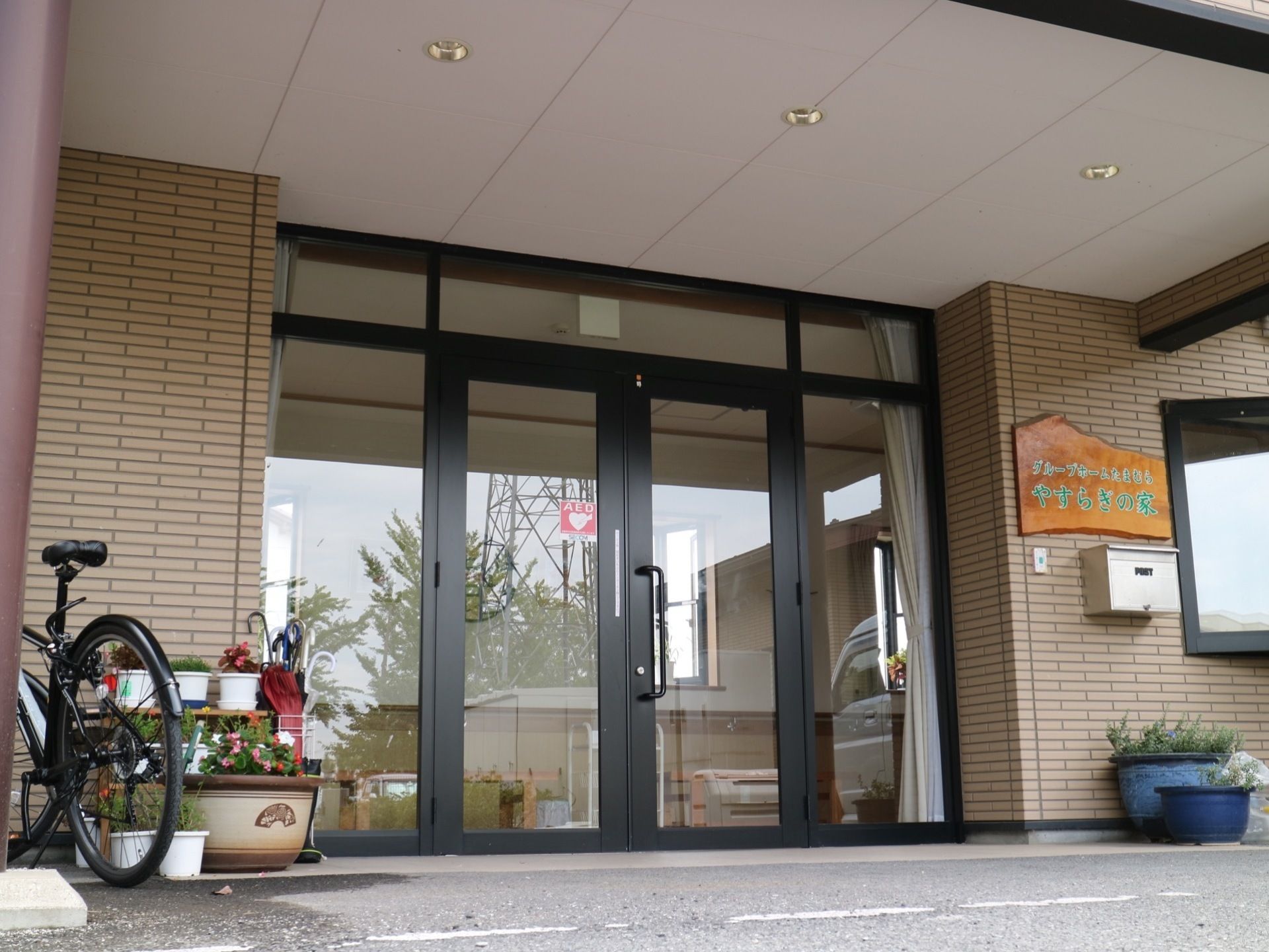 鉢植えが飾られ自転車が停まっている玄関