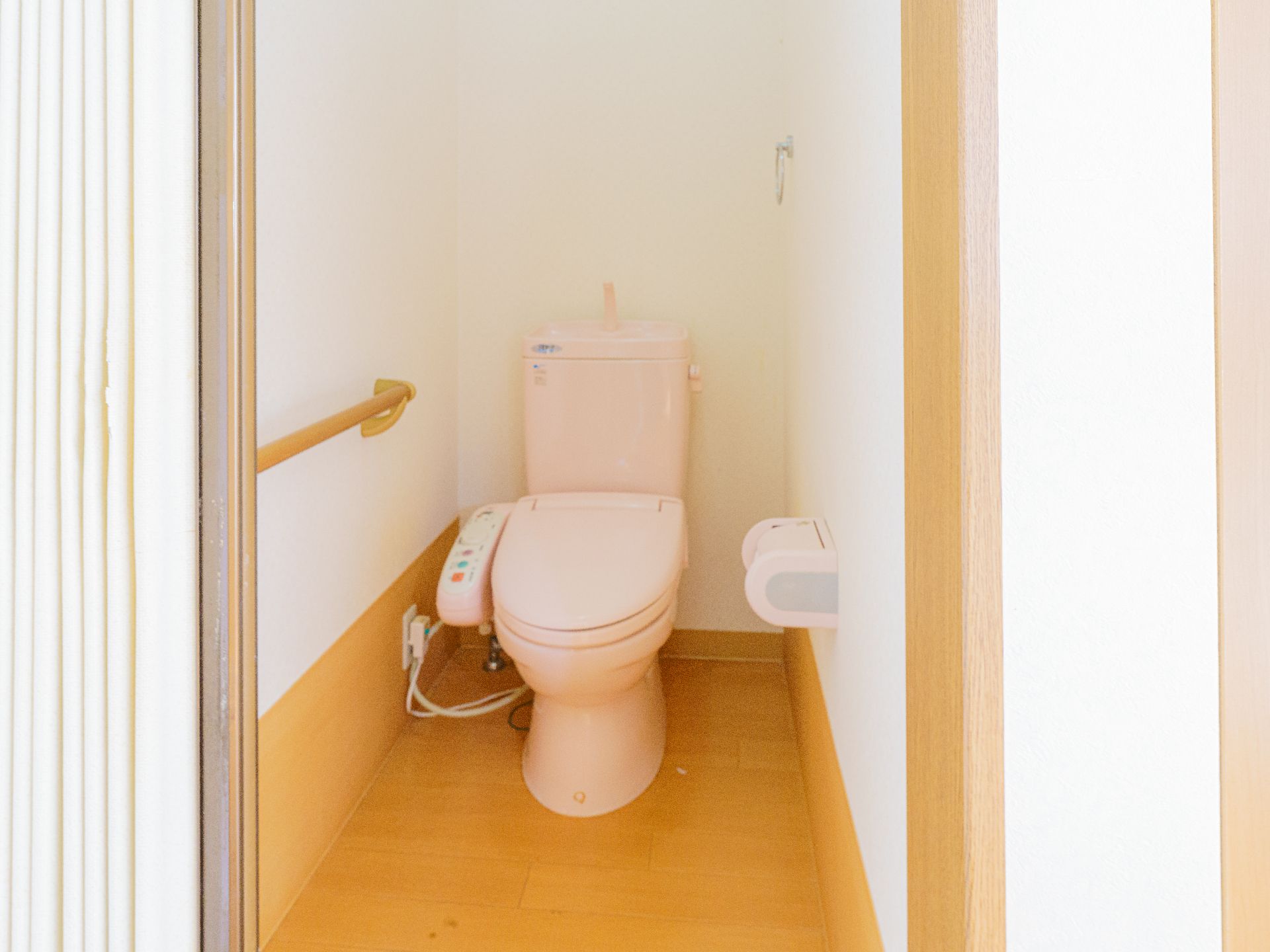高齢者でも楽に座ることが可能な、手すりのついたトイレ