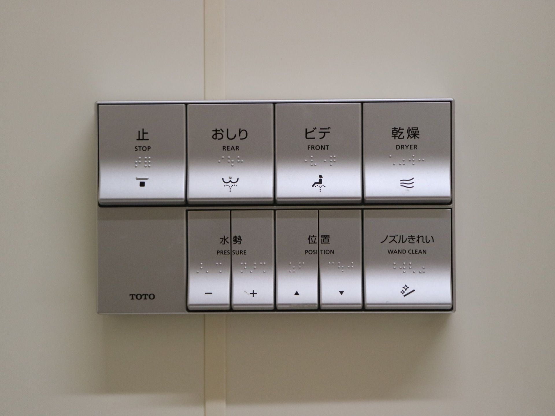 トイレの壁に取り付けられたパネルで、シルバーのボタンが並んでいる。温水洗浄のほか、乾燥などの機能がある。