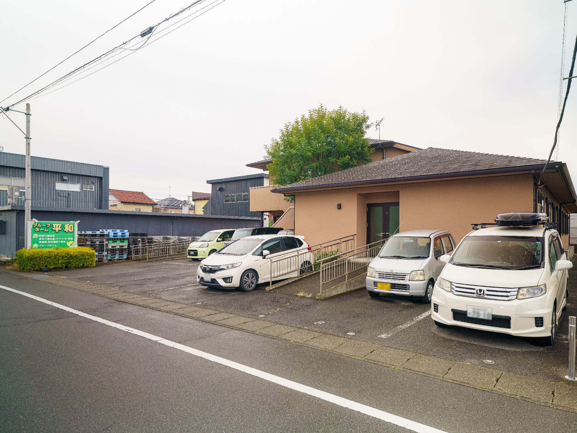 広い駐車場が隣接している灰色の介護施設