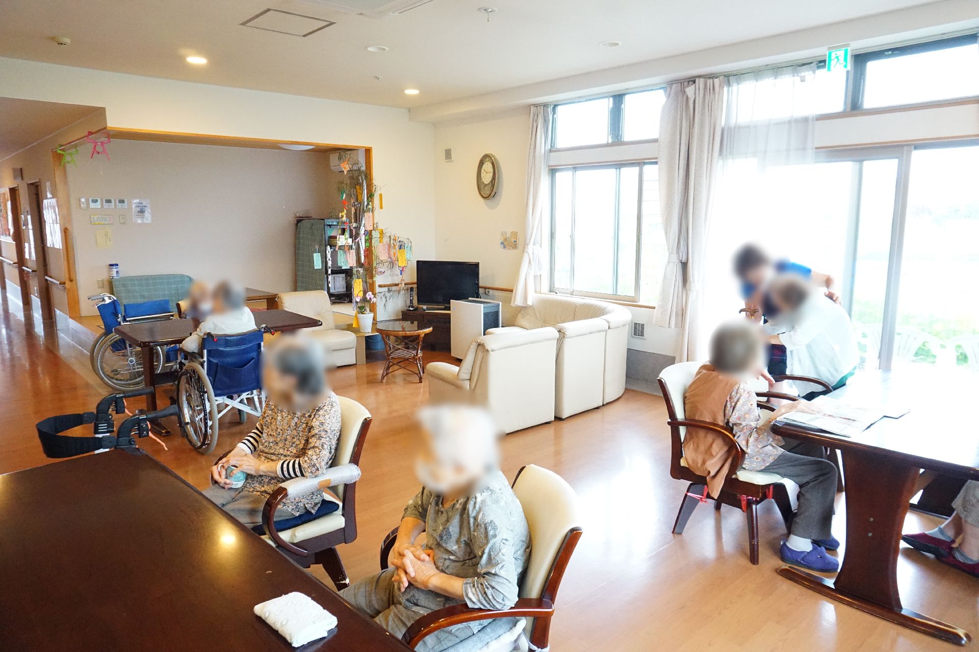 大きな窓から陽光が降り注ぎ、大きなテーブルが設置されているリビング
