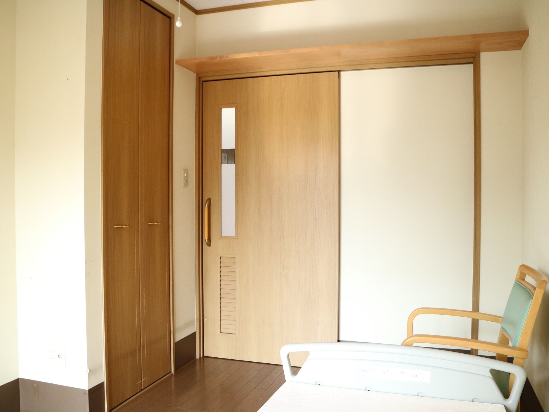 居室のドアは引き戸になっており、細長い窓が付いている。ドアの左側にはクローゼットが設置されており、右側には椅子が置かれている。