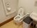 広いトイレには、洗面台も設置されている。可動式やL型手すり、呼び出しボタンが壁に取りつけられている。