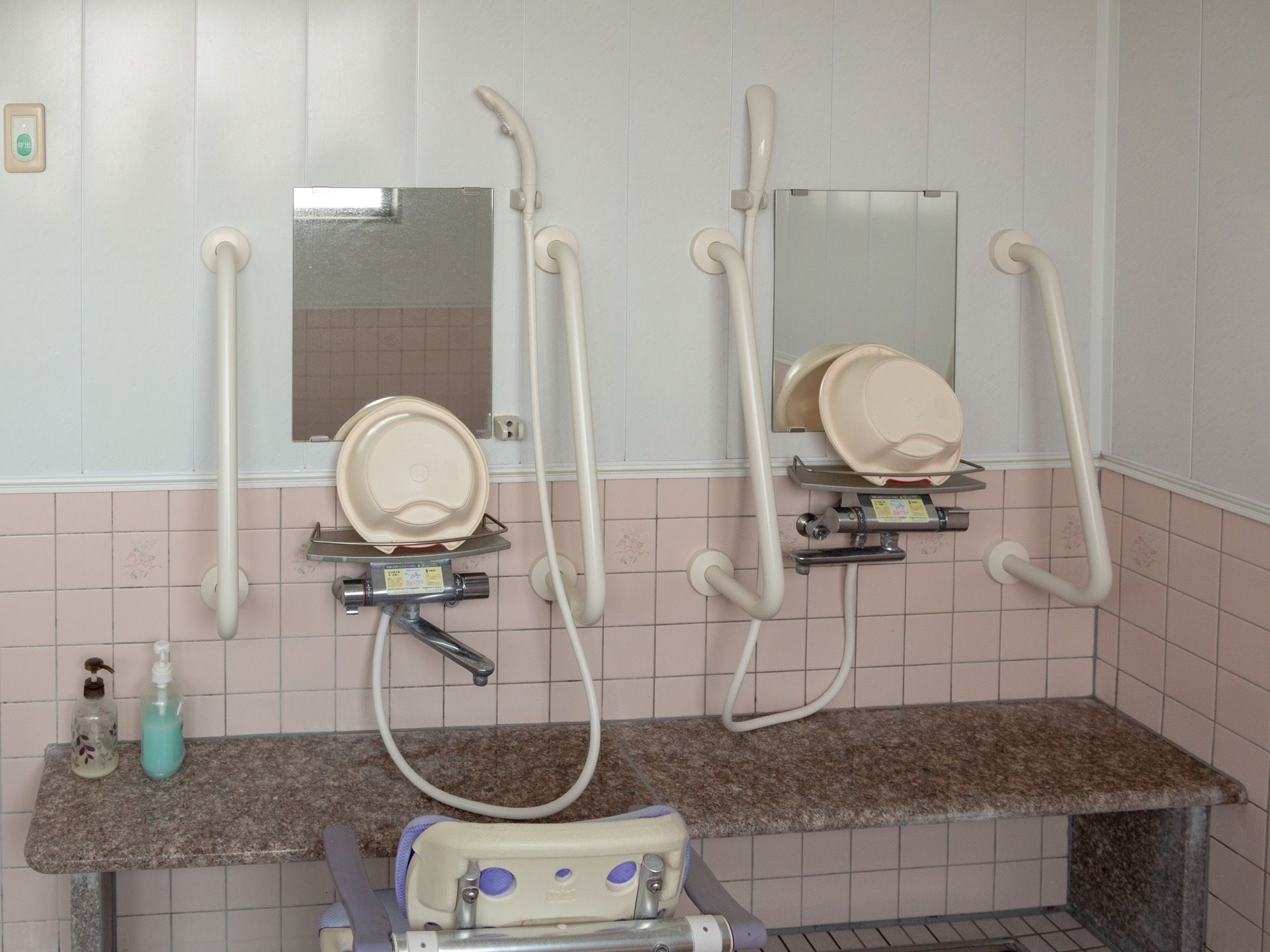 浴室内に複数のシャワーが設置されている。それぞれ前方の壁に鏡や洗面器が備わっているほか、つかまり用の棒やシャワーチェアも配備されている。
