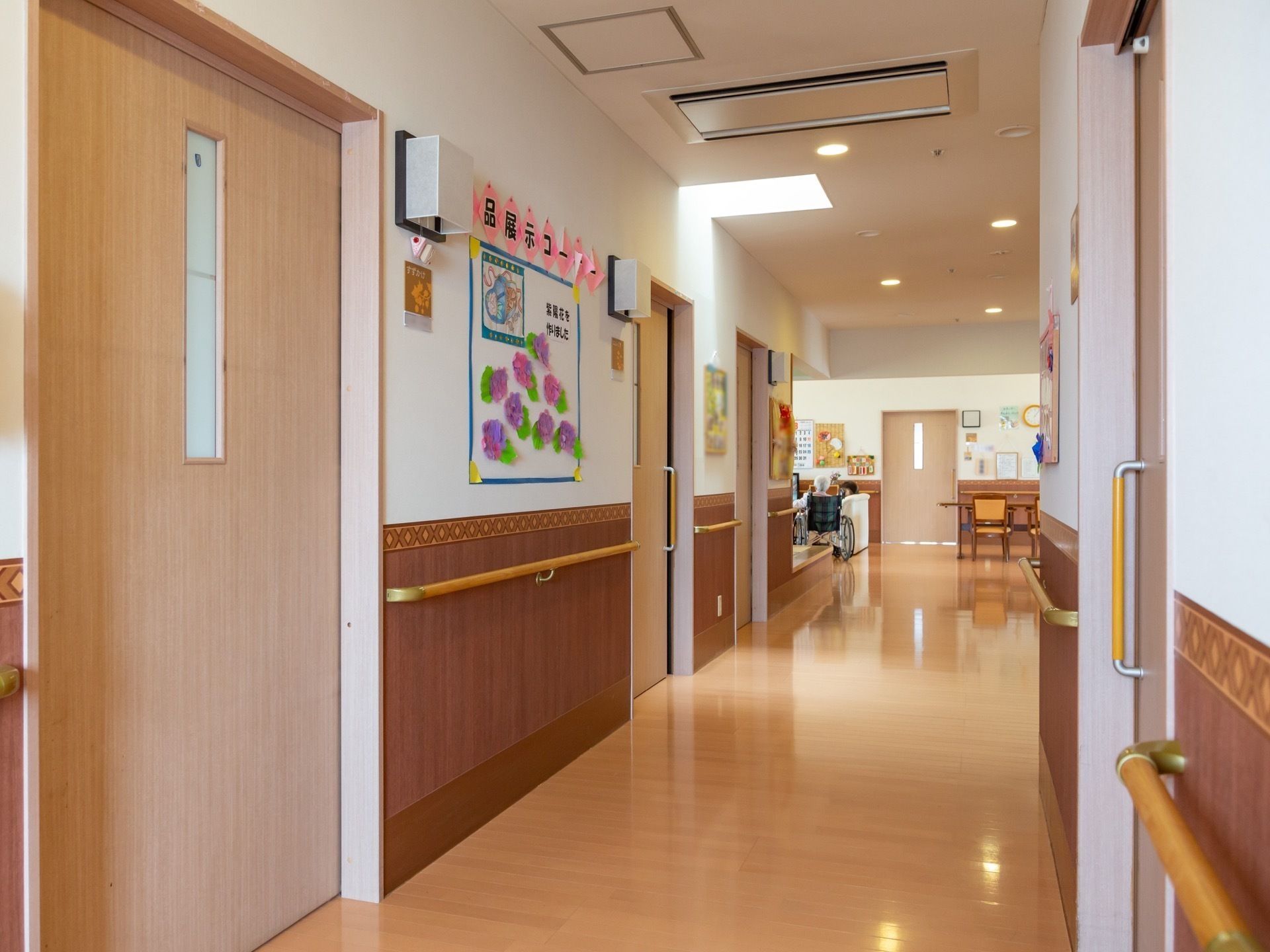 共有廊下は直線で見通しがいい。両側面に手すりが設置され、居室の扉が並んでいる。各扉は手すりタイプの取っ手付き引き戸になっている。