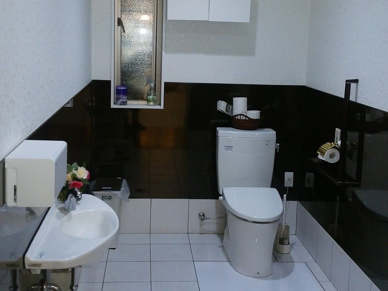 広いトイレには手洗い場もあり、壁には手すりやトイレットペーパーホルダーが付いている。