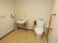 広々としたトイレには、ウォシュレット付きの洋式タイプを設置している。また洗面台もあり、壁には手すりが備え付けられている。