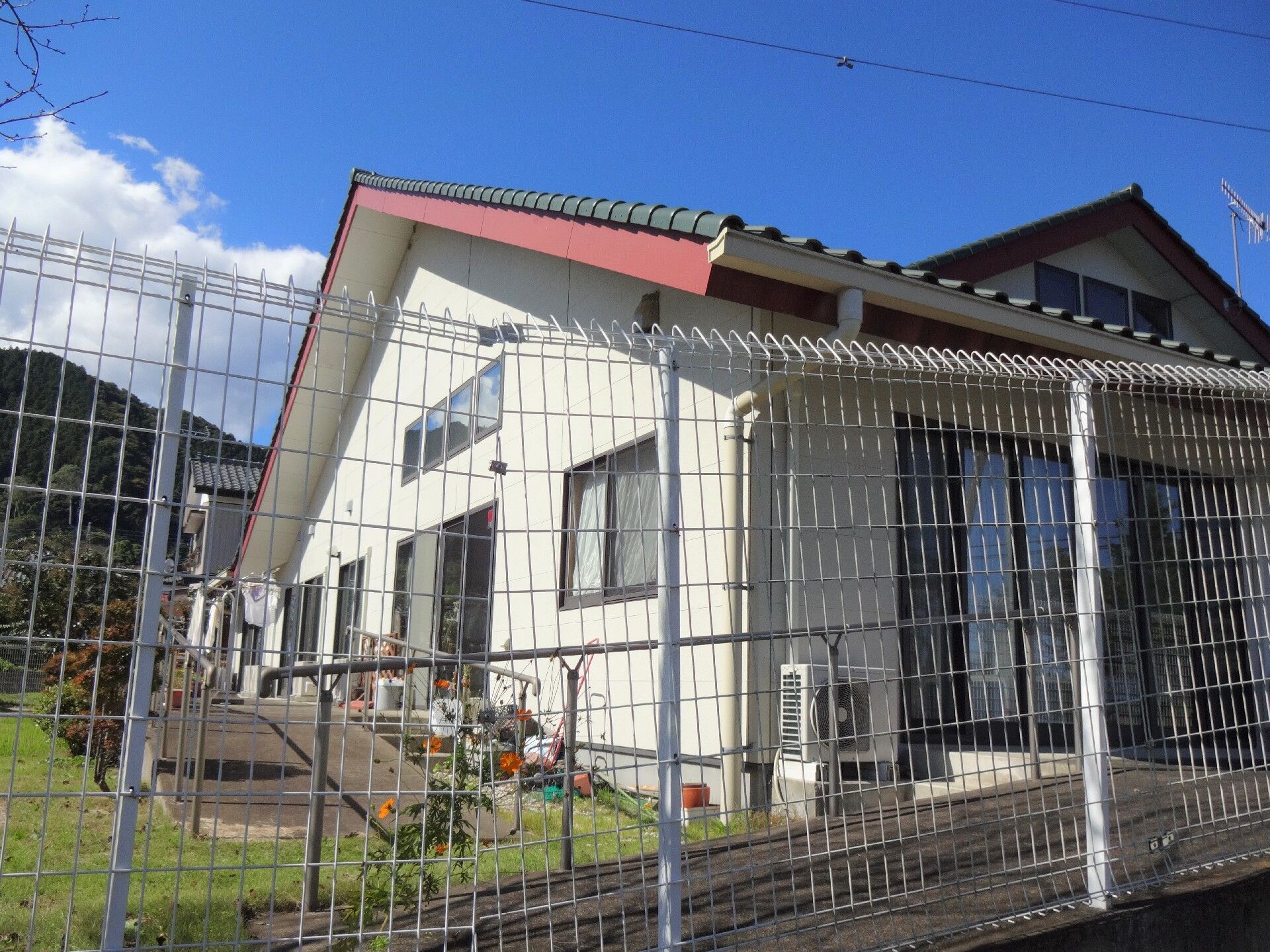 食卓に座ってお茶を待つ女性入居者3人と、お茶の準備をする女性スタッフ。奥にはキッチンが見える。