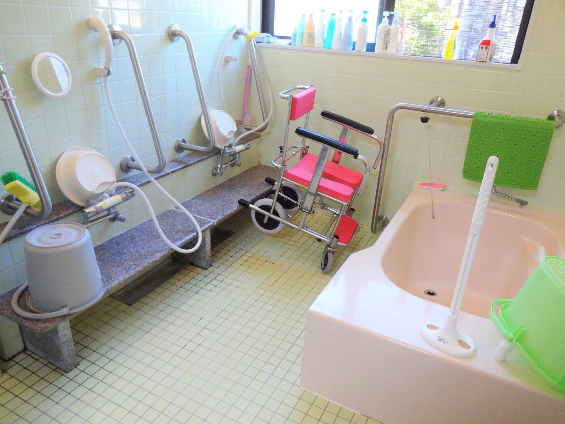 浴室には流し場が２か所用意されている。それぞれに洗面器備えつけられている。介護用椅子が置かれている。