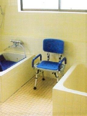 ブルーのイスが置かれた居室。両横に浴槽がある。