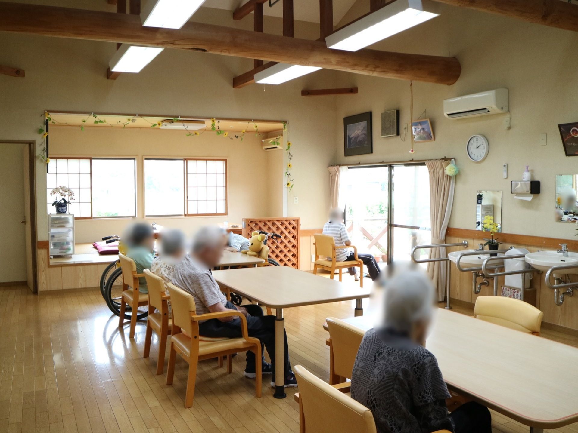 梁が行きわたった吹き抜けの天井に照明が４か所取り付けられている。右手の壁には洗面台が２か所に用意されている。