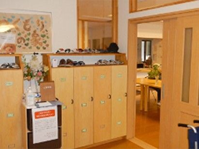 木材をたっぷりと使用した館内には手作りの看板が飾られ、靴箱や車いすもあり、奥には共有スペースもある。