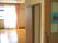 フローリングの部屋には大きな窓が付き、カーテンが設置されている。家具はないがトイレのドアがあり、開いている。