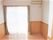 エアコンがついたシンプルで何も置かれていないワンルームタイプの部屋。窓がついていて外につながっている様子