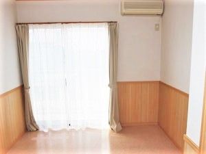 エアコンがついたシンプルで何も置かれていないワンルームタイプの部屋。窓がついていて外につながっている様子