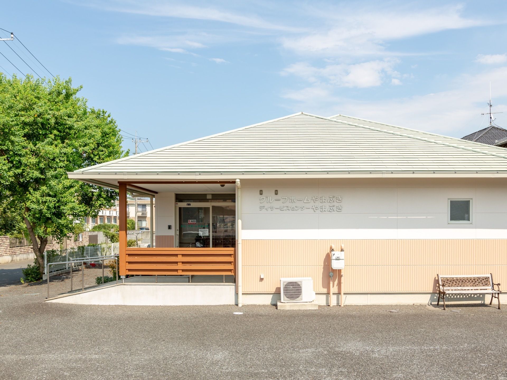 白とオレンジのツートンに塗られた建物である。壁に大きく施設名が表示されている。入口はガラス扉になっている。