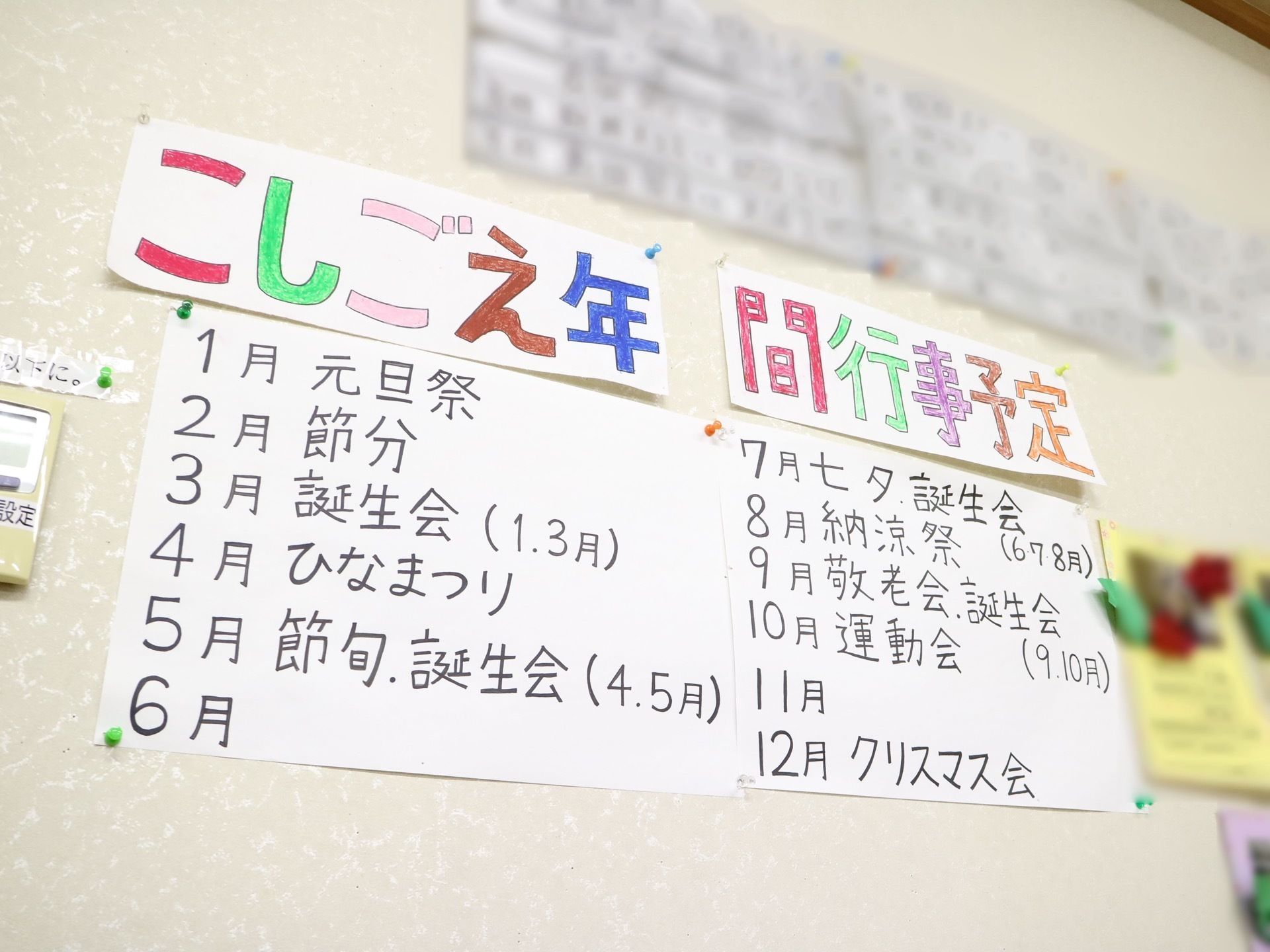 白い壁に年間行事予定が貼られている。大きな字で読みやすく書かれており、色を変えて書いている部分もある。