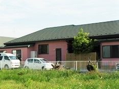 一軒家のようなデザインの施設の外観。温かみある色合いと通常住宅のような屋根