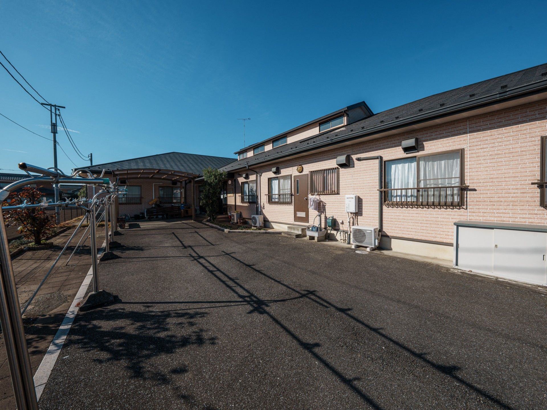 なにかを指さして笑顔で話している車いすの女性とそれを押している介護スタッフの様子