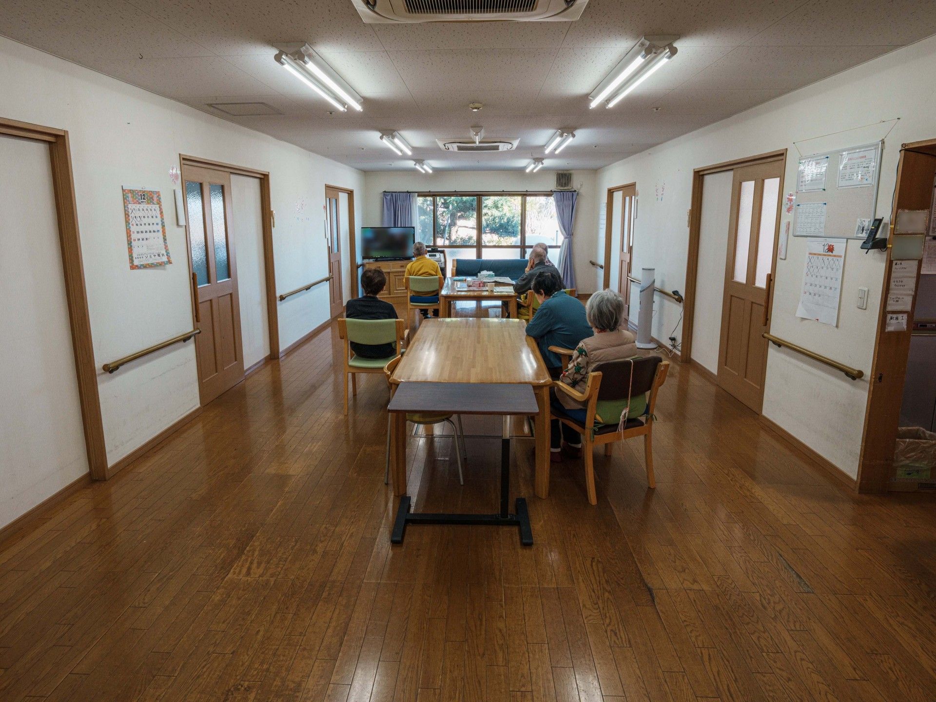 歩行訓練を行っている高齢者とそれをサポートするスタッフ2人