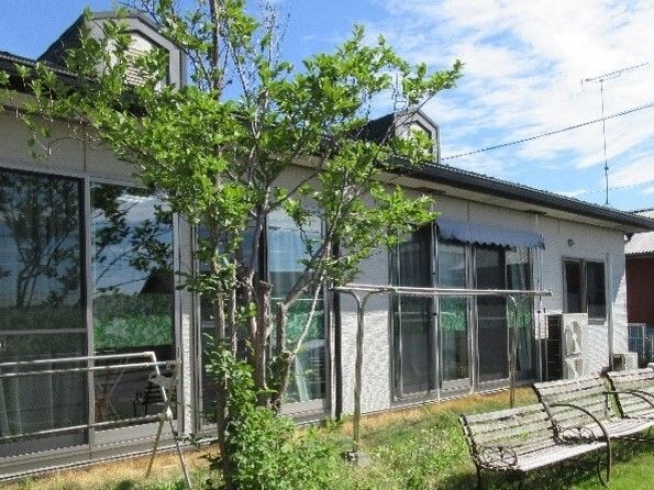 緑の多い庭には木製のベンチが複数置かれ、大きな窓が付いている共有スペースから出入りができる洗濯物干し場がある。