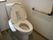 個室トイレの図である。温水洗浄便座を取り付けた洋式トイレである。操作パネルは便座の横に設置されている。