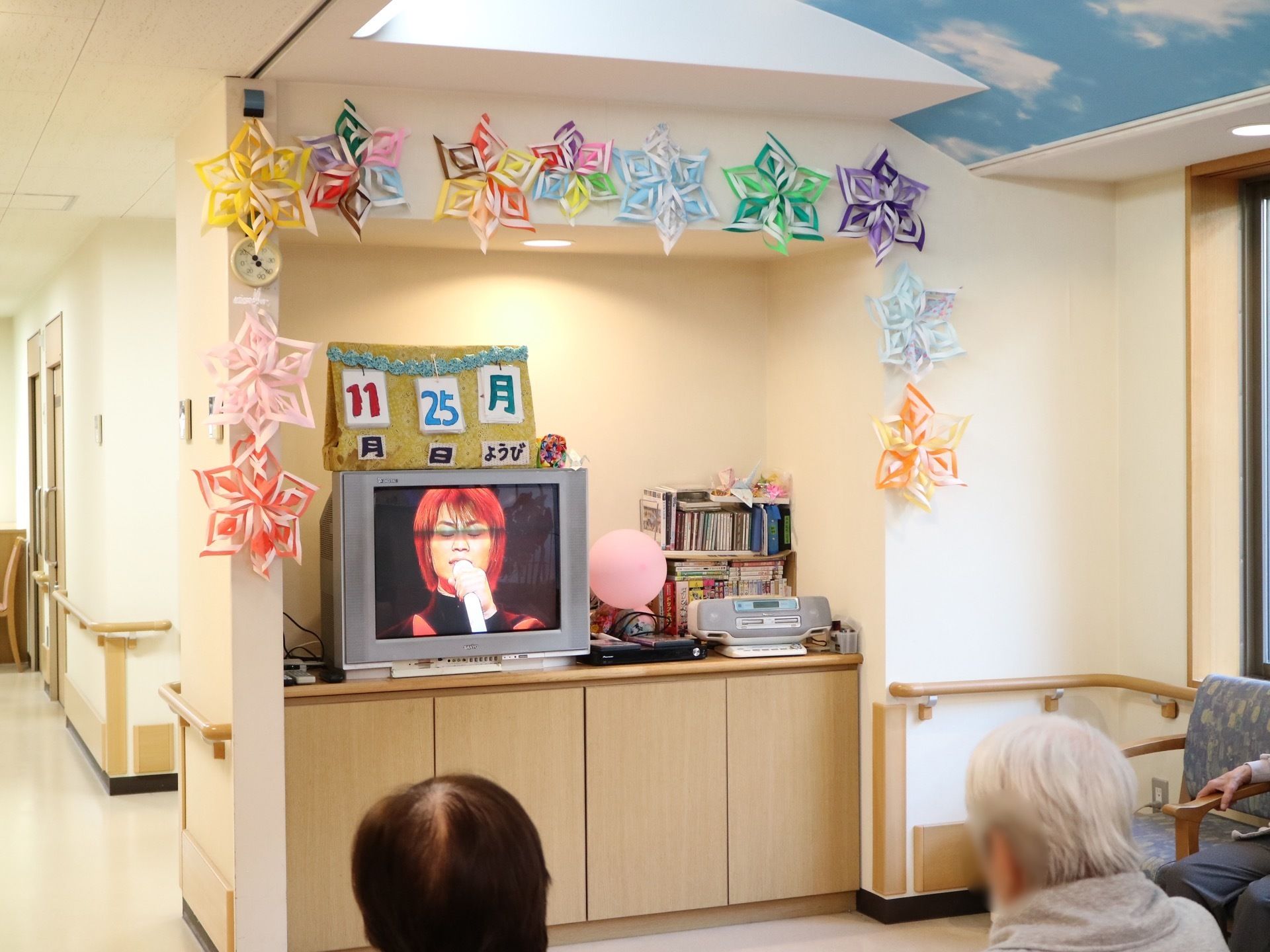 共有スペースの一角には壁をくり抜かれた棚があり、液晶テレビやラジカセが置かれている。壁に装飾が施されている。