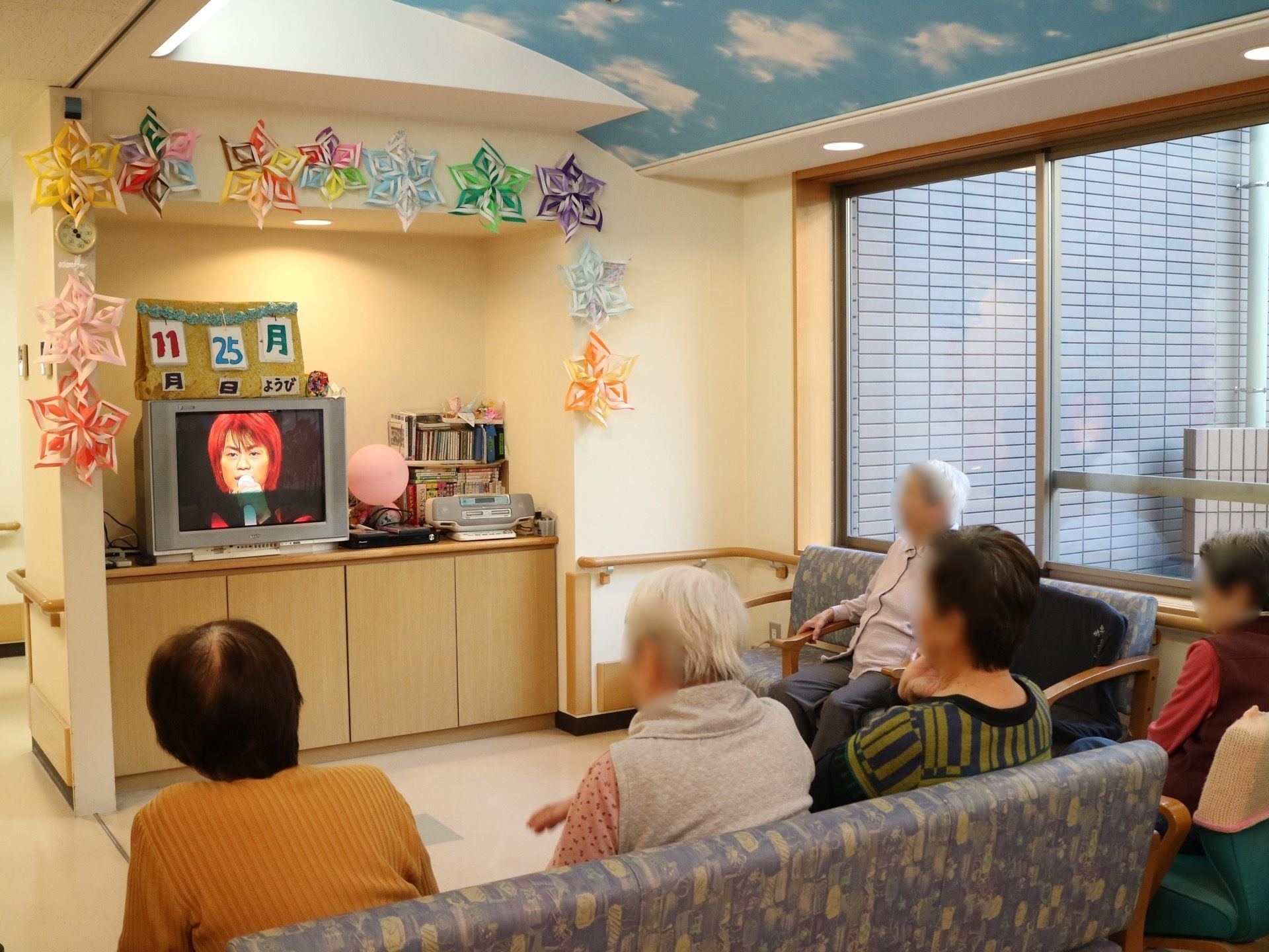 ソファーでくつろぎテレビを鑑賞する高齢者