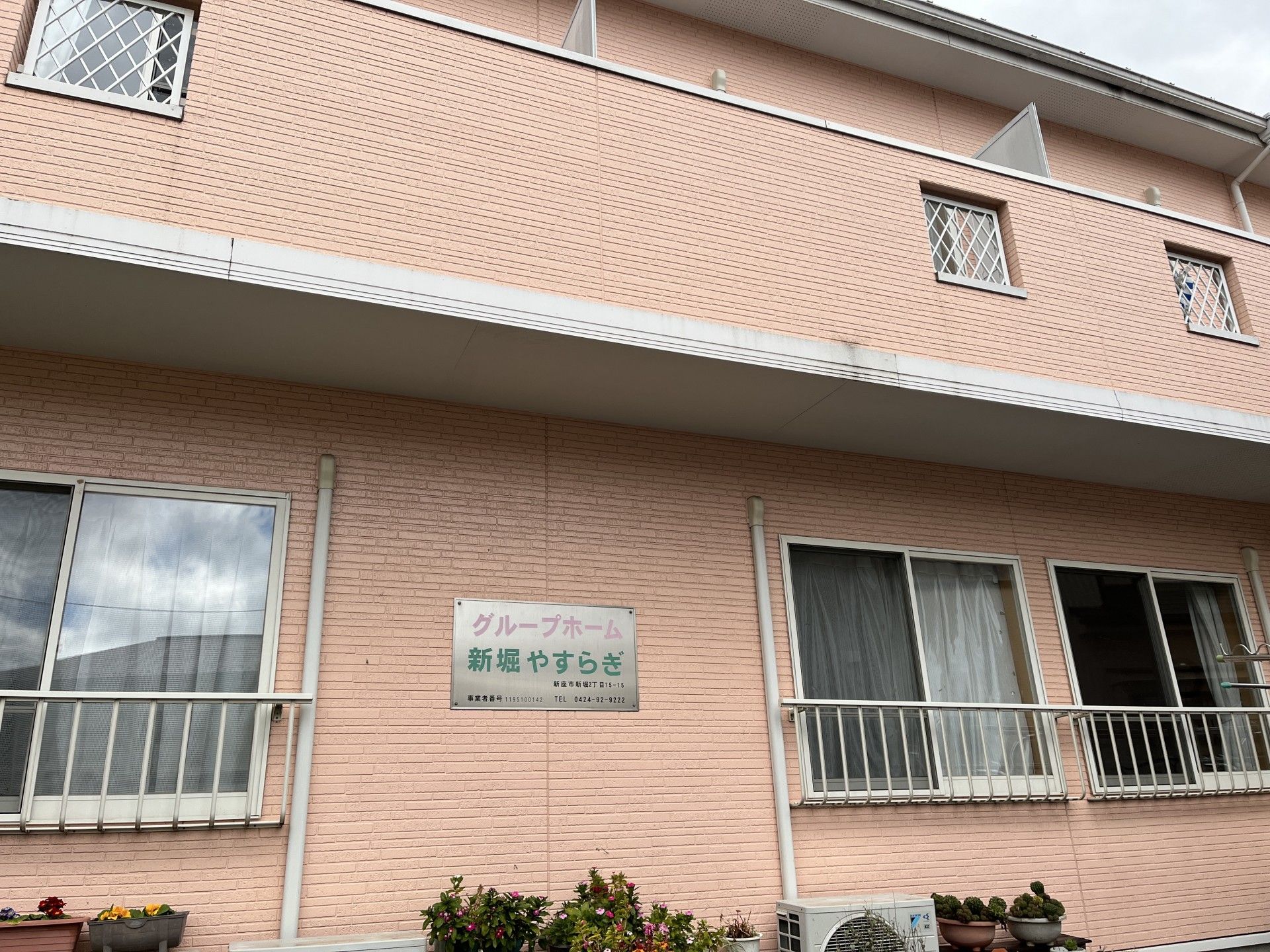 鏡を見ながら笑顔で話している高齢者とそこに寄り添介護スタッフの様子。明るい室内の写真