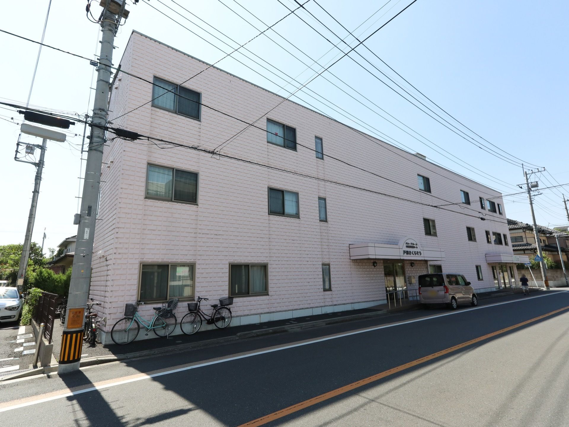 優しいピンク色の外壁の3階建て施設である。周囲は緑が残る住宅地で、静かで穏やかな生活を送ることができる。