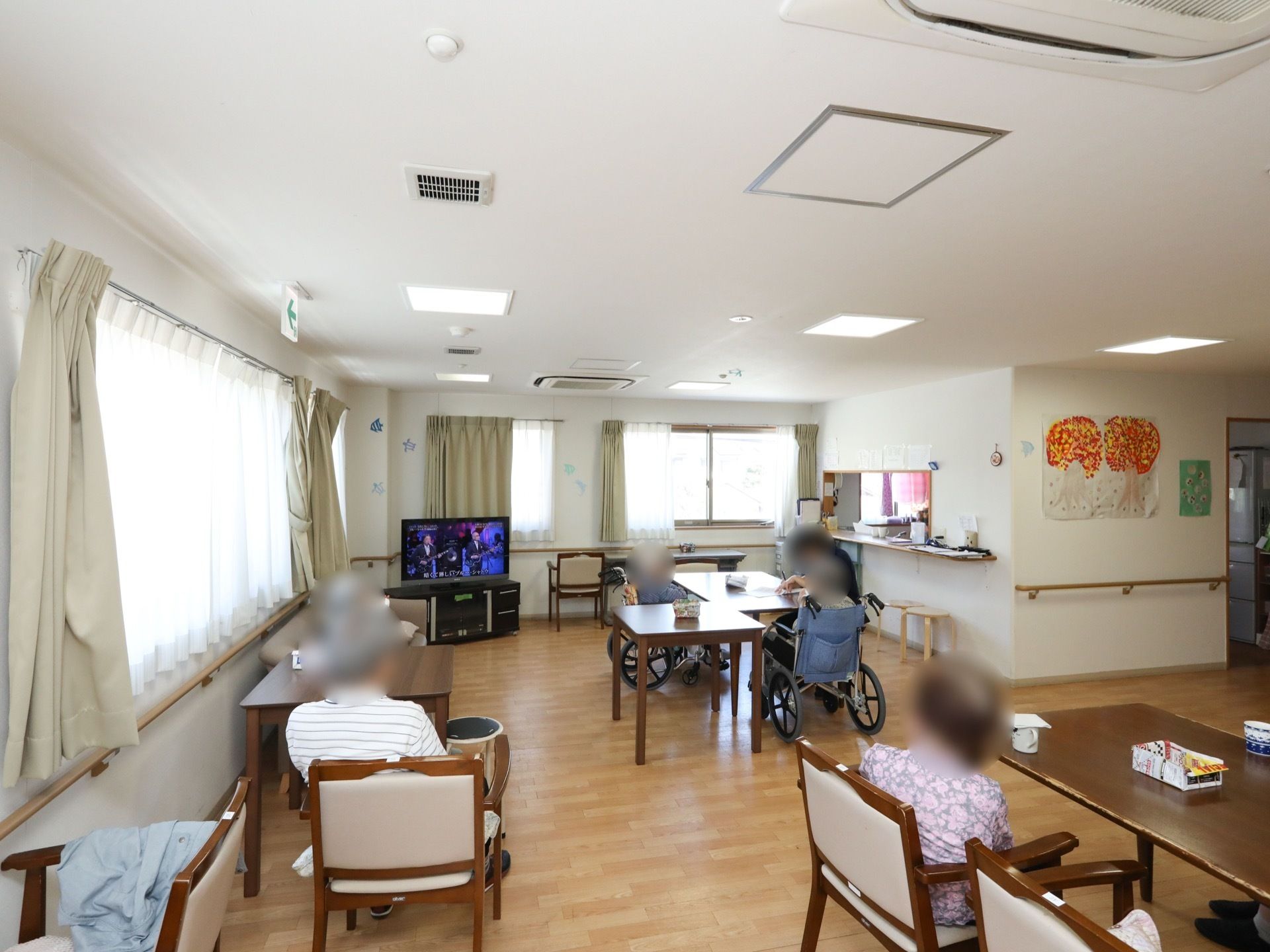 食堂兼リビングルームとして利用される共有スペース。壁一面に手すりを設置し、安全に移動できるようにしている。