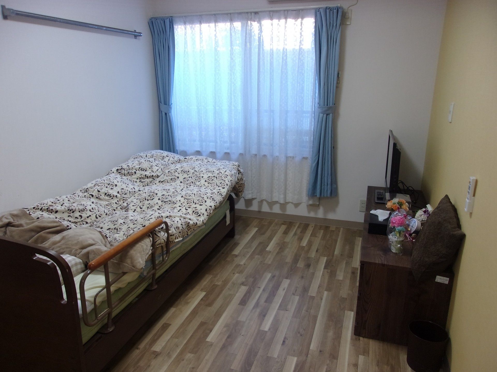 車いすの女性と同じ視線で話している介護スタッフ。やわらかい表情で散歩している様子