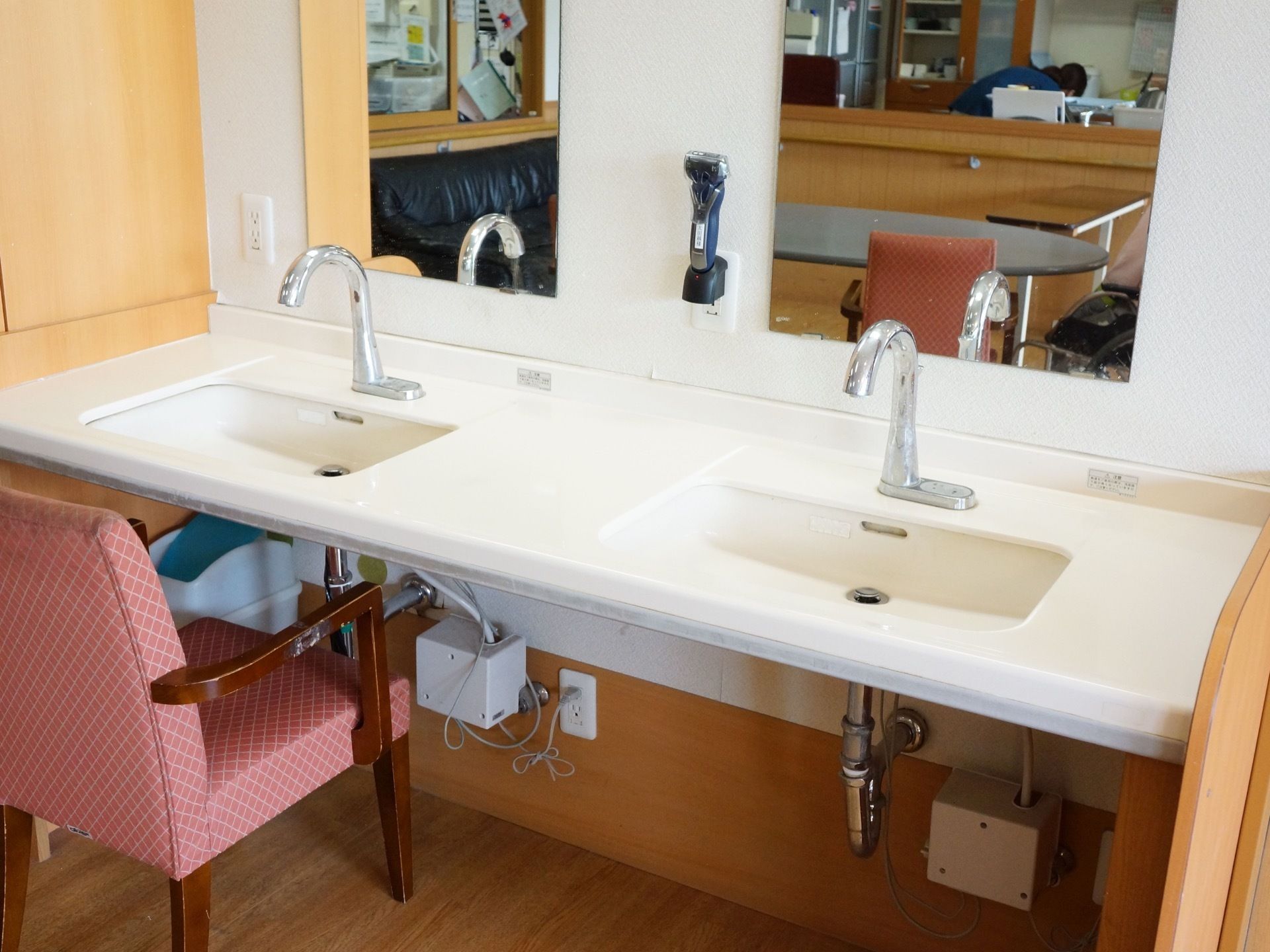 共有スペースに用意された洗面台は、センサー式の蛇口を設置している。電気カミソリと、椅子が用意されている。