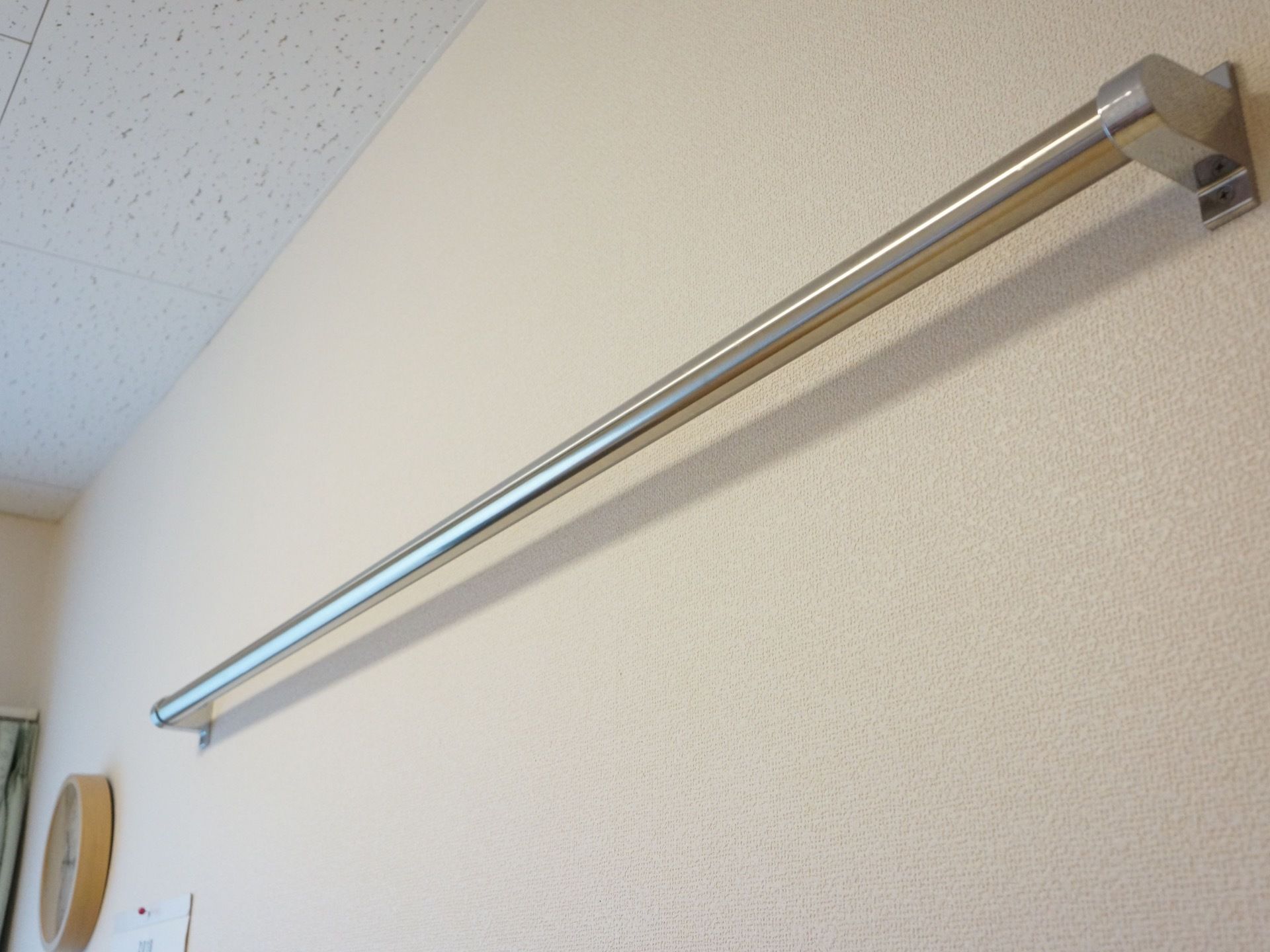 居室の壁の上部に鉄製のパイプが設置されている。ハンガーやフックなどを下げて収納場所を作ることができる。