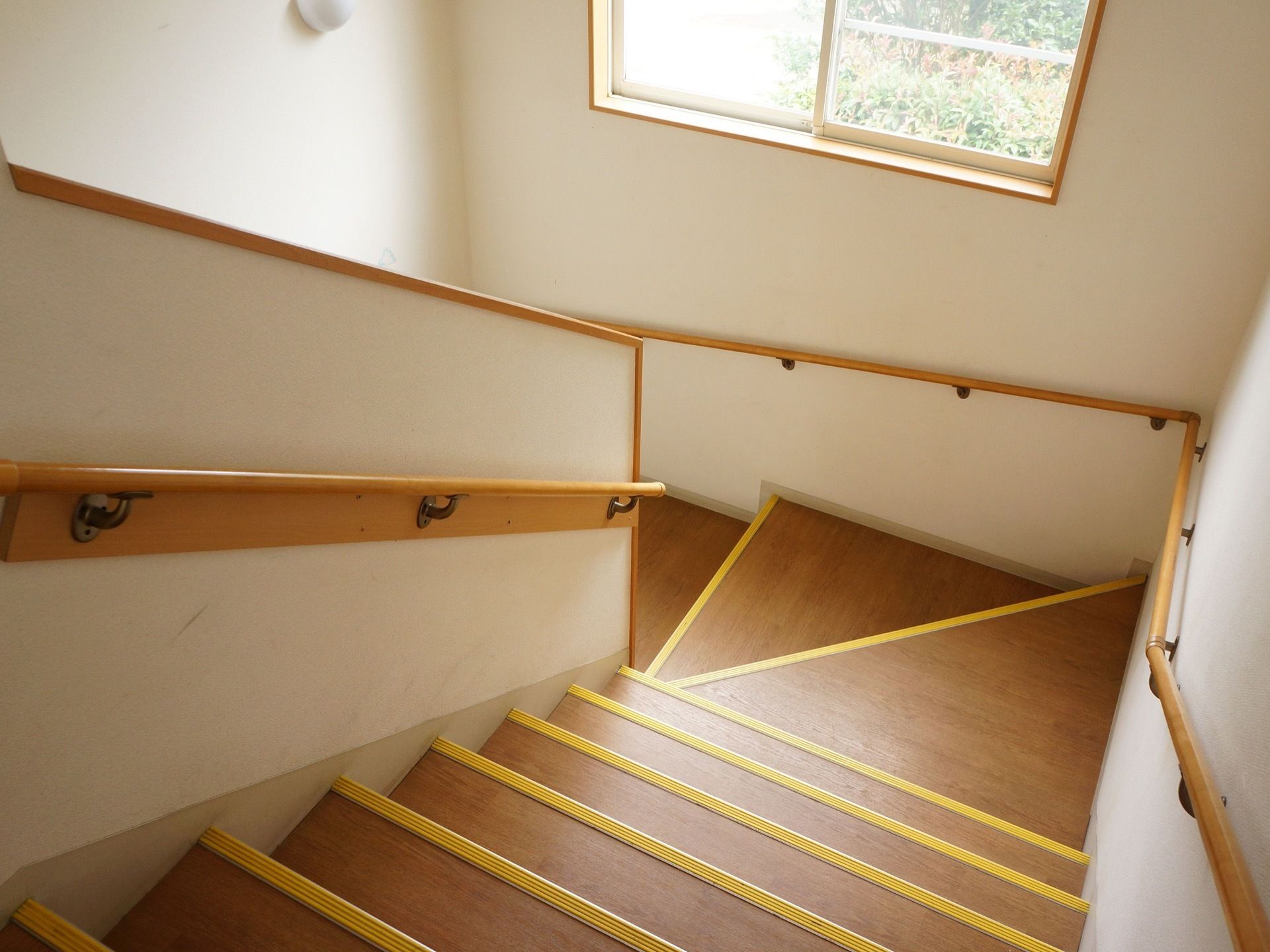 階段には大きな窓があり、日中は足元を明るく照らしている。夜間は照明で明るい。壁の両側に手すりが取り付けられている。