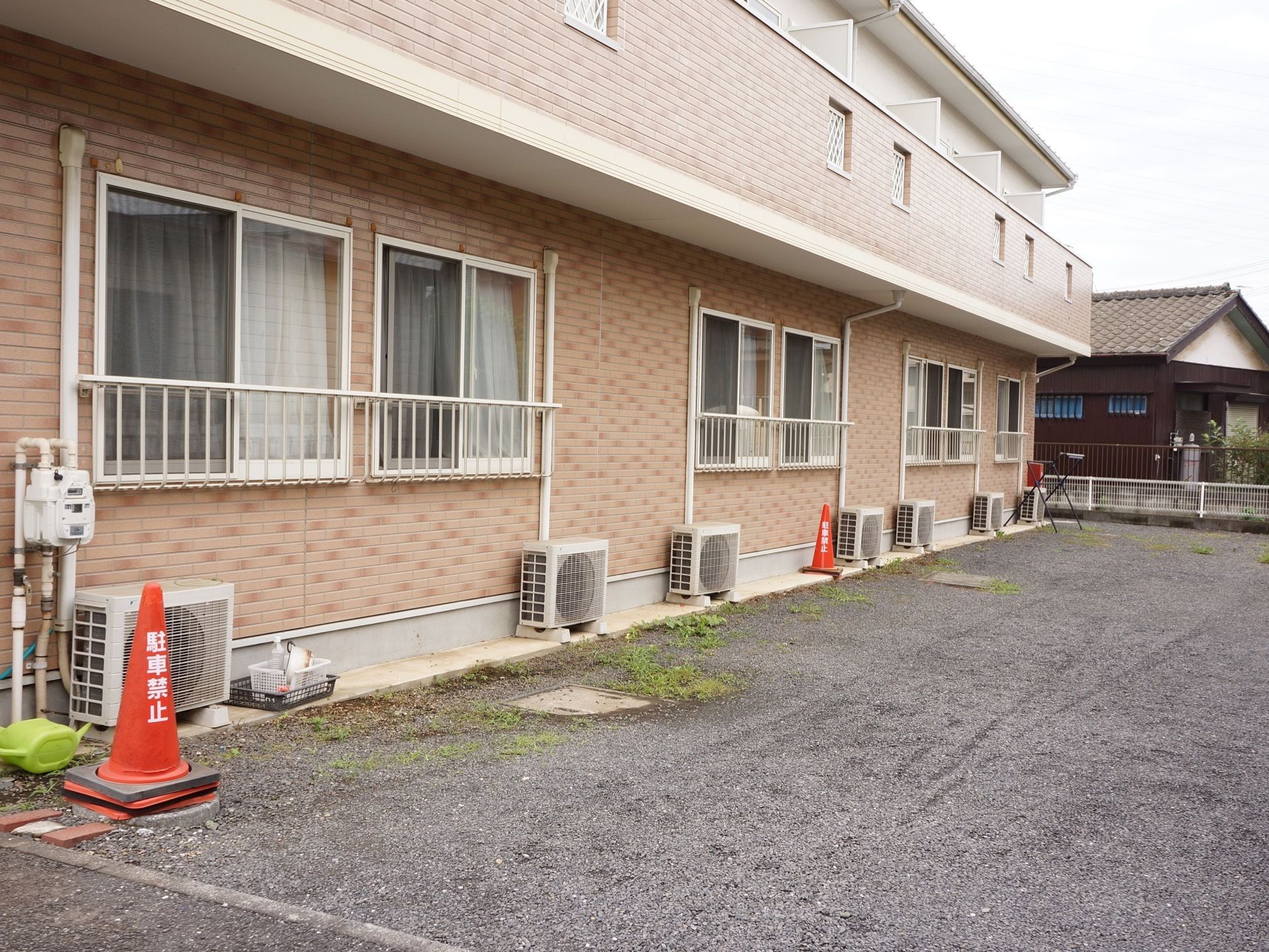 ピンクのタイルに囲まれた外観になっている。施設前は砂利のスペースが広がっており、各居室からの景色は開放感が溢れる。