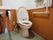洋式の便器が備わるトイレの個室である。可動式の手すりやL字型の手すり、緊急時呼び出しブザーなどの設備がある。