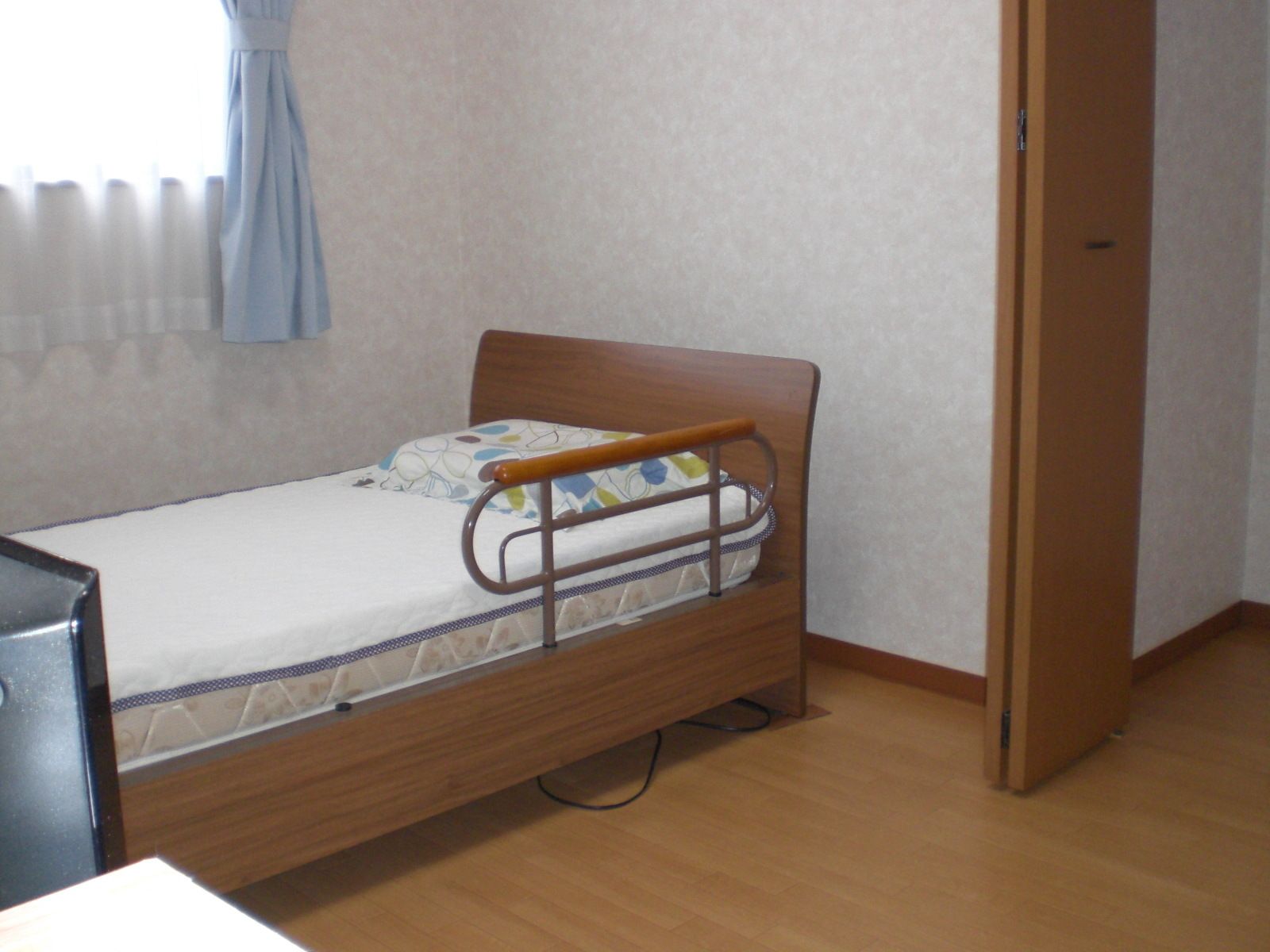 シンプルだが清潔感のある部屋。ベッドの上にマットレス。床は段差がない。
