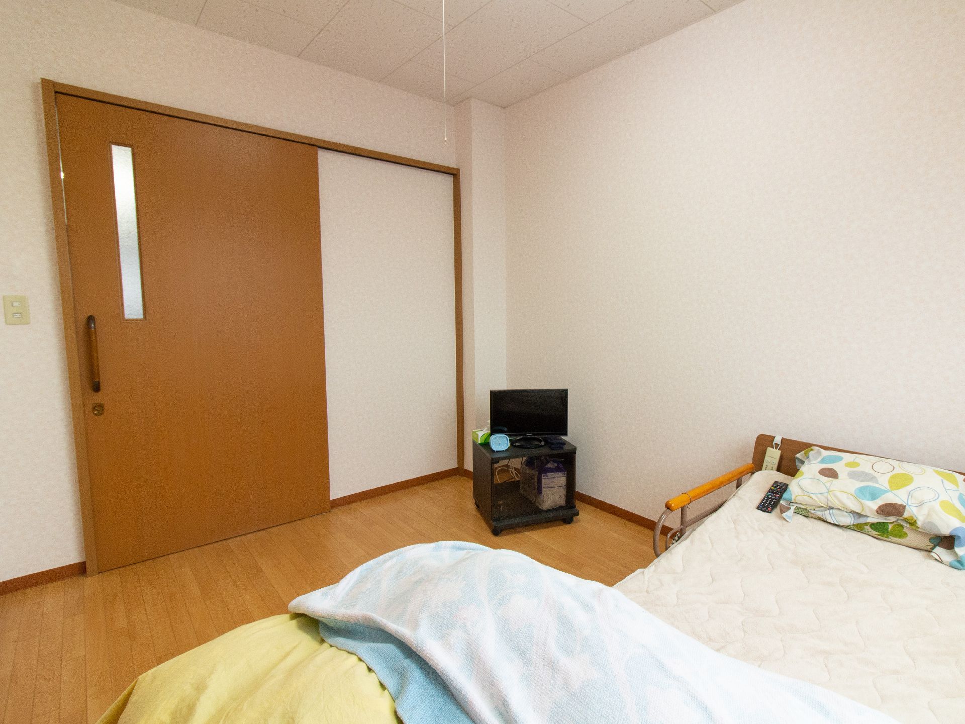 介護用ベッドやテレビが置かれた、スライドドアの居室