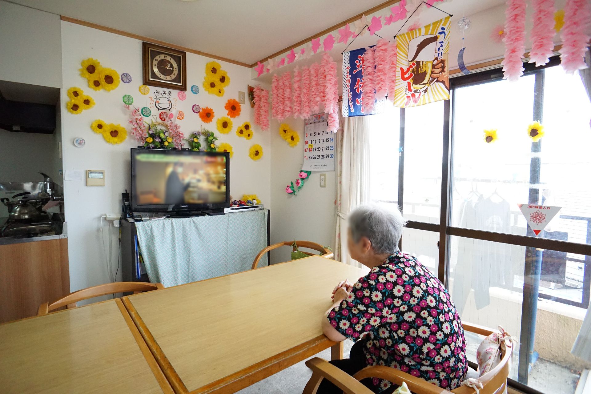 輪になってレクリエーションをする高齢女性と女性スタッフ