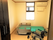 部屋の奥に介護用ベッドと小さな窓があるワンルームの部屋の中。手前に車いすも見えている様子